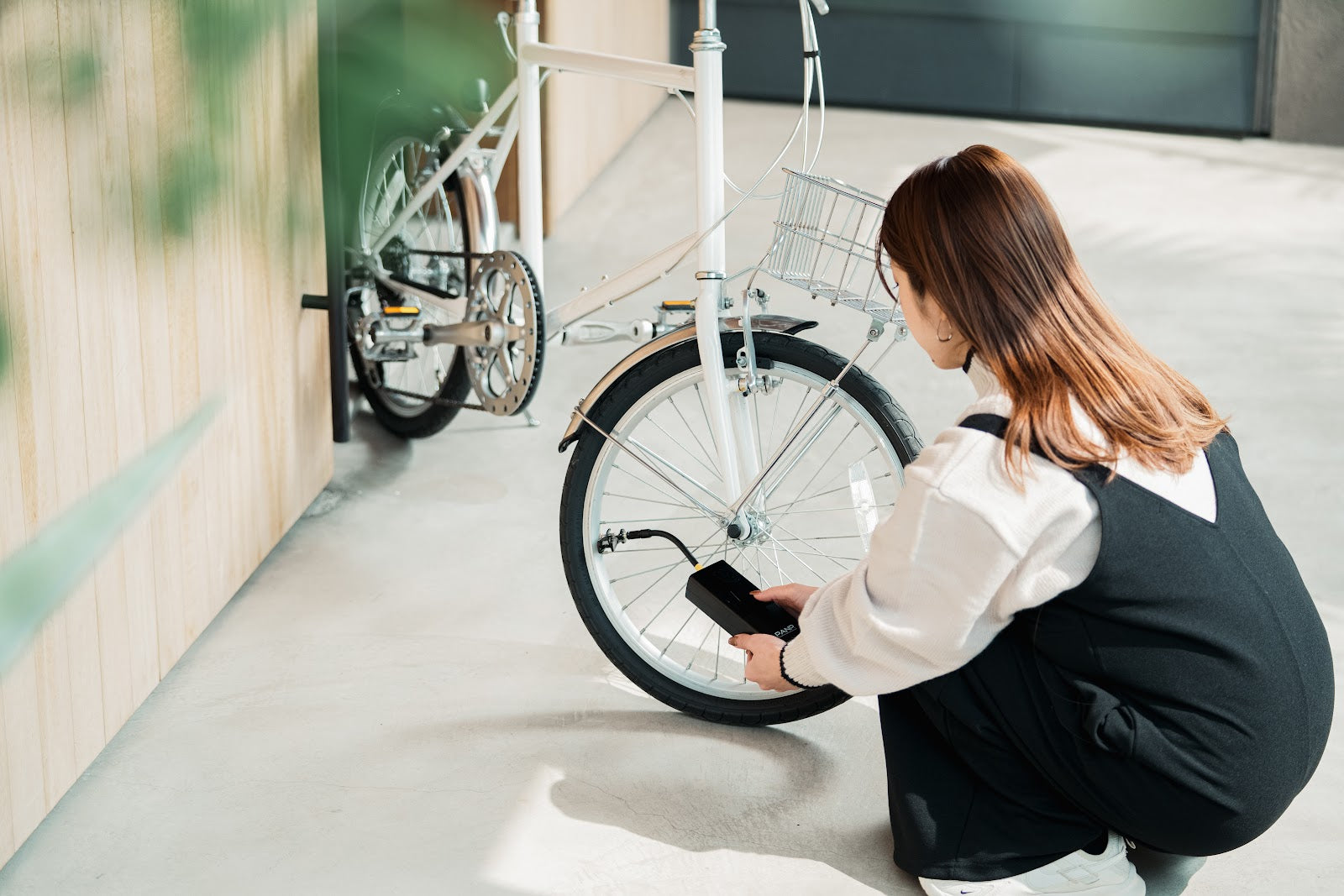 駐輪場で、自転車のタイヤに PANP RIDE をつないでいるところ