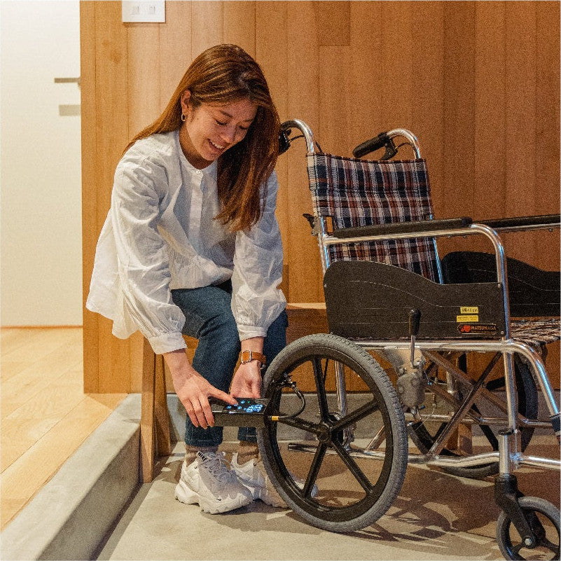 車椅子のタイヤに空気を入れる女性