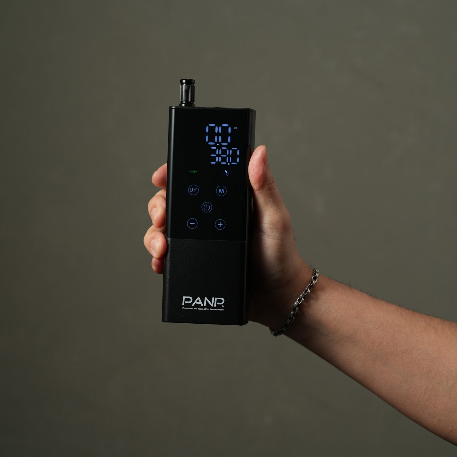 手に持った PANP RIDE 本体。画面と操作ボタンが見えている