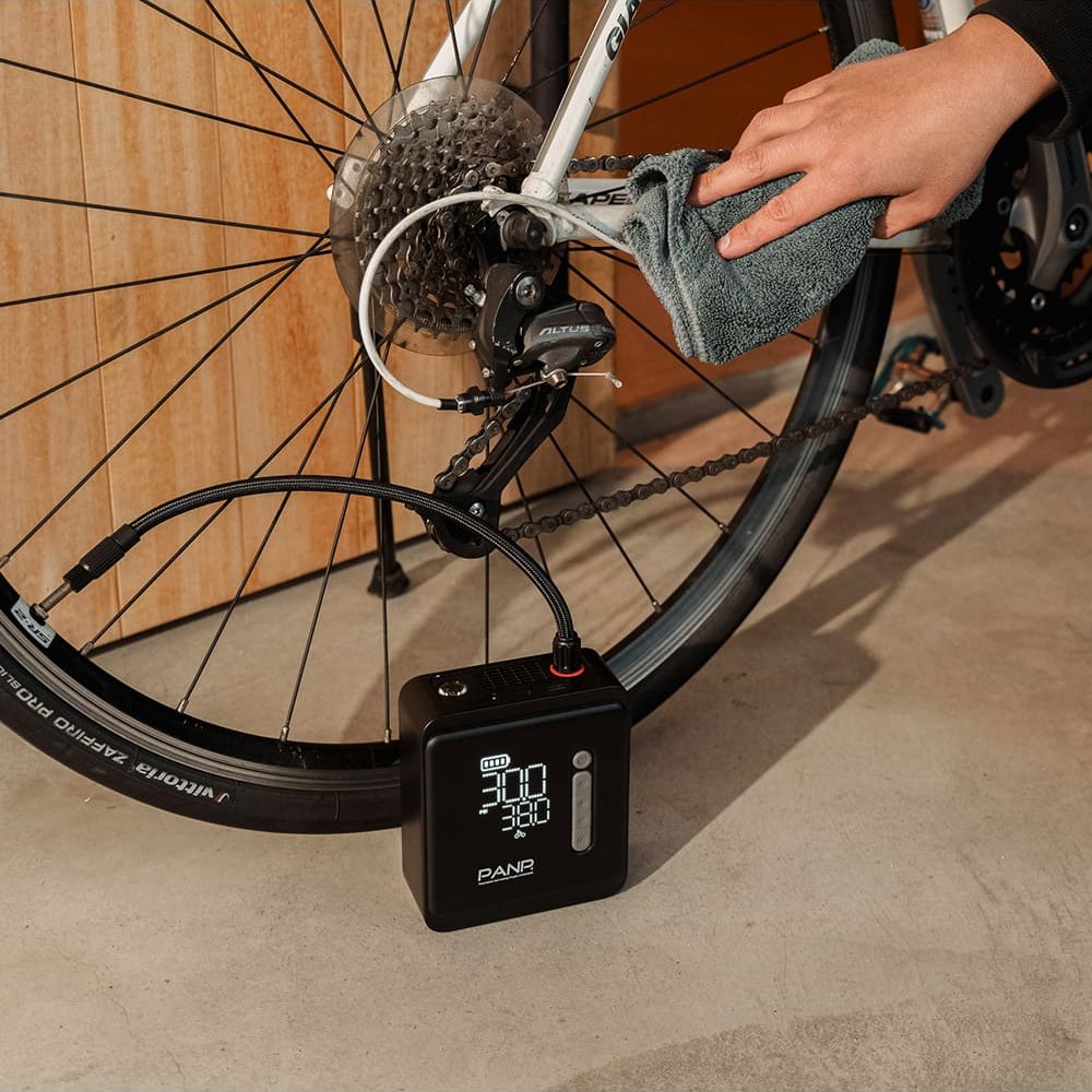 ロードバイクの後輪に PANP RIDE PRO をつないで空気を入れているところ