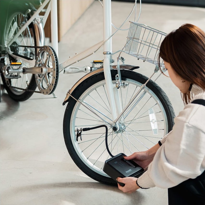 自転車のタイヤに空気を入れる女性