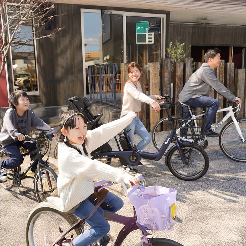 家族で自転車に乗って出かけているところ