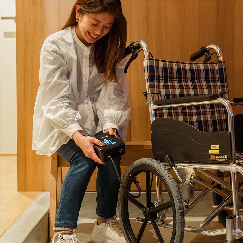 車椅子のタイヤに空気を入れる女性