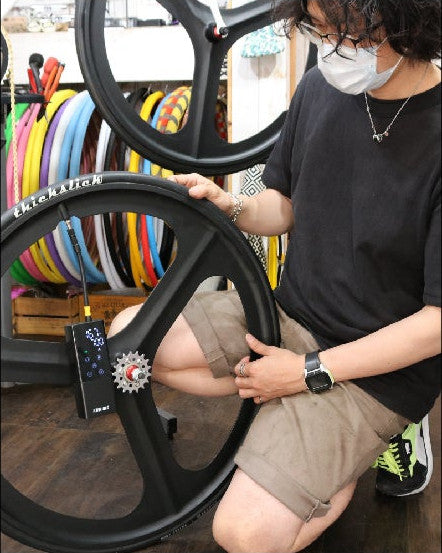 ライダーズカフェの店内。スタッフが自転車のホイールに PANP RIDE をつないでいる