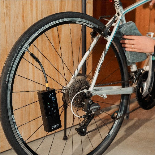 ロードバイクの後輪に PANP RIDE をつないで空気を入れているところ